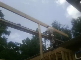 Carpenter setting a ridge beam over a new addition frame — Ice Dam Removal by Roofing Brothers in Cocolalla